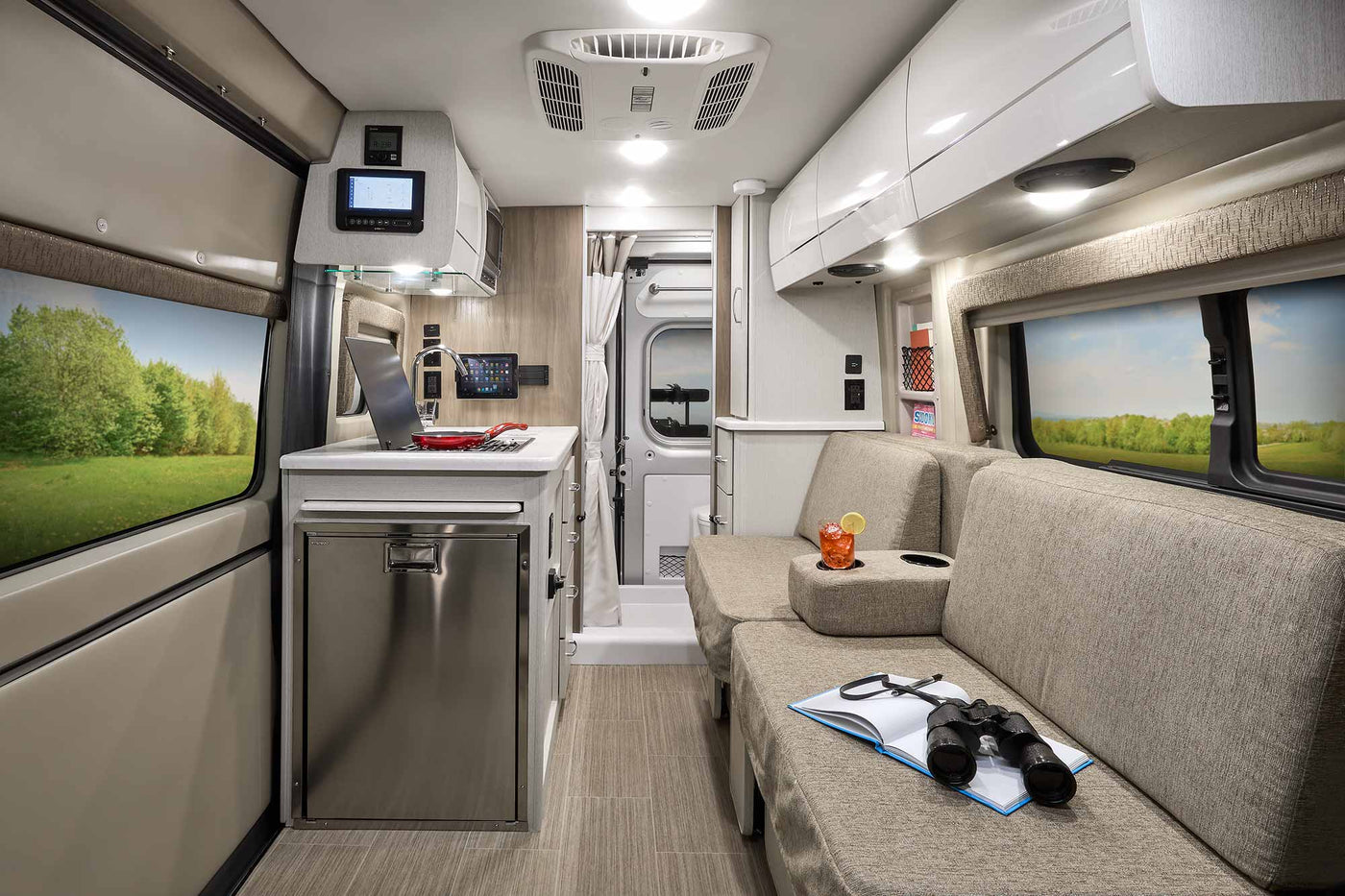 Modern RV rental interior with kitchenette, lounge seating, and scenic window views. Perfect for your next road trip adventure. — photo 13