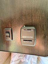 Suburban RV thermostat and light switch on wood panel wall, set to 70°F/21°C. Essential for rv rental climate control.