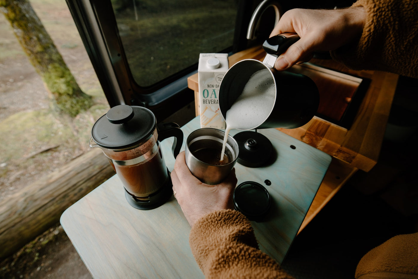 Enjoying a fresh oat milk latte, poured from a pitcher into a travel mug, next to a French press in an RV rental. — photo 10