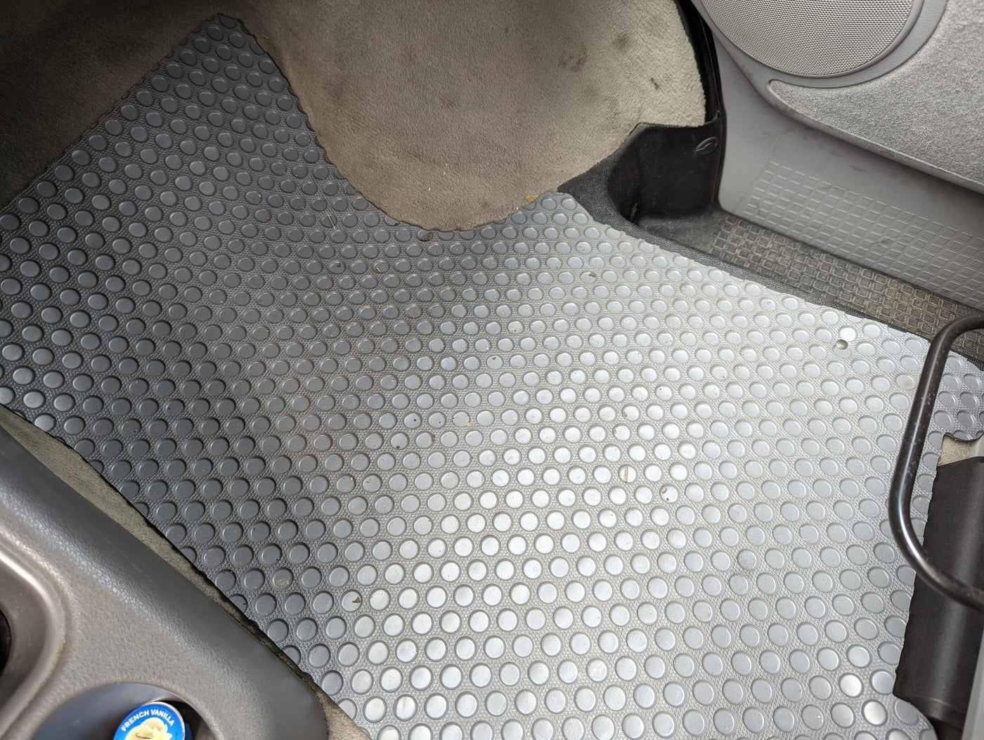 Gray rubber floor mat with circular texture in an RV rental. Visible carpet, speaker, and console details. — photo 15