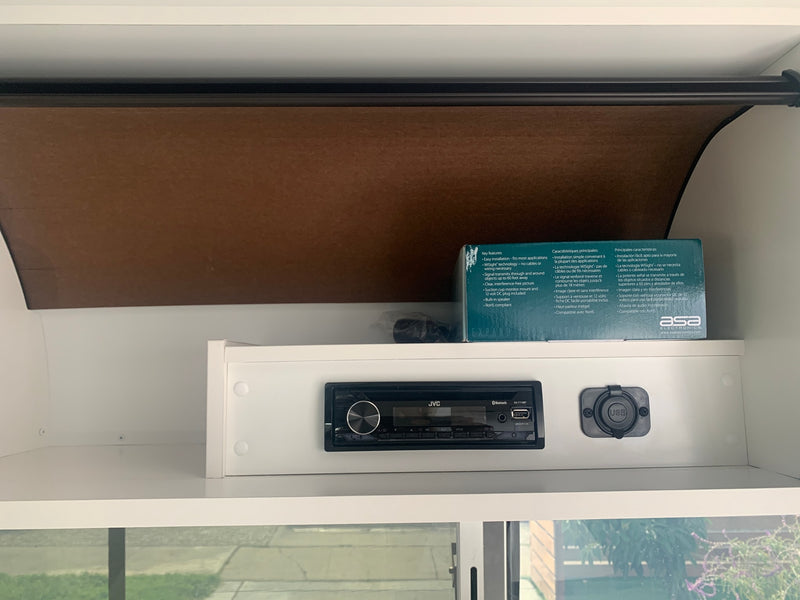 RV rental interior: JVC stereo, USB charging, and an ASA Electronics WiSight box are seen in a storage cabinet. — photo 14