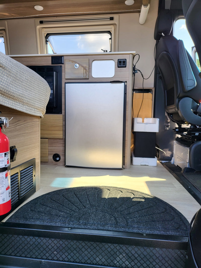Inside a cozy rv rental: compact kitchen (fridge, microwave), sleeping area, & safety gear. — photo 9