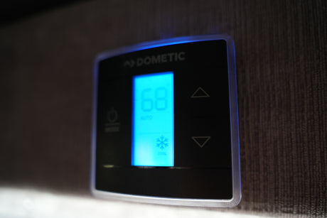 RV rental Dometic climate control set to cool at 68°F in auto mode, with clear up/down temperature controls.