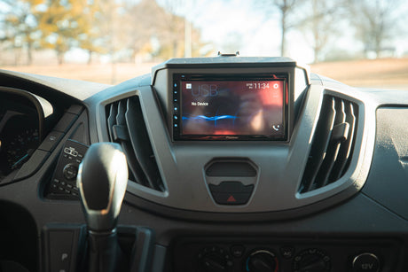 Inside an RV rental: a modern dashboard featuring a Pioneer infotainment screen, climate controls, and gear shift.