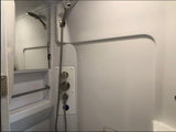 Experience comfort in this clean, compact RV rental shower, featuring a handheld head, modern controls, and built-in mirror/shelves.