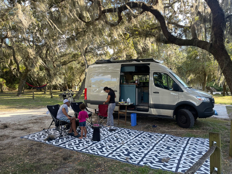 Family enjoying an RV rental Sprinter van campsite, relaxing outdoors under moss-draped trees. — photo 9