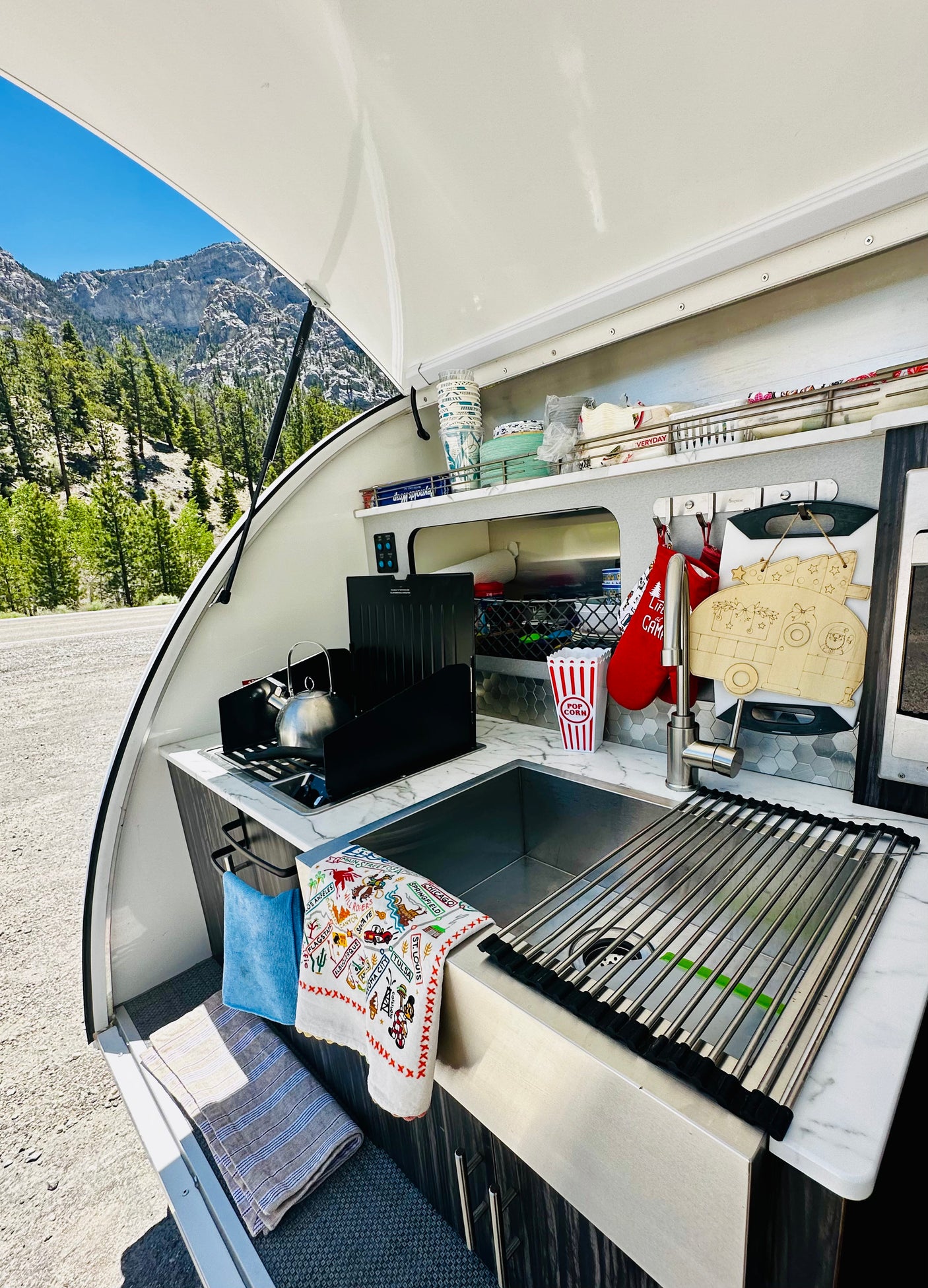 RV rental galley kitchen with sink, stovetop, and mountain views. Perfect for camping adventures.