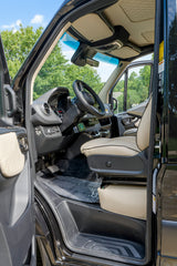 Inside this rv rental: a pristine driver's cockpit with cream leather seat, detailed dashboard, and visible pedals.