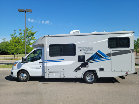 Sleek grey Coachmen Cross Trail Class C RV rental parked outdoors, ready for your next travel adventure.