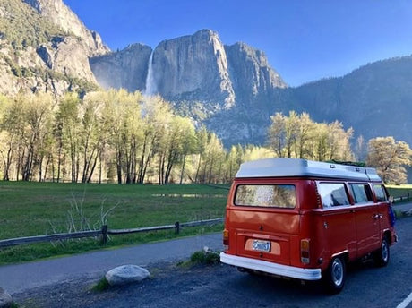 Explore Yosemite! This red RV rental camper van parked near Yosemite Falls captures nature's beauty and adventure.