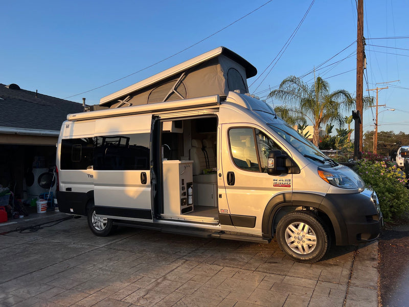  with mountains and a blue sky.|Experience mobile living! This silver pop-top camper van — photo 2