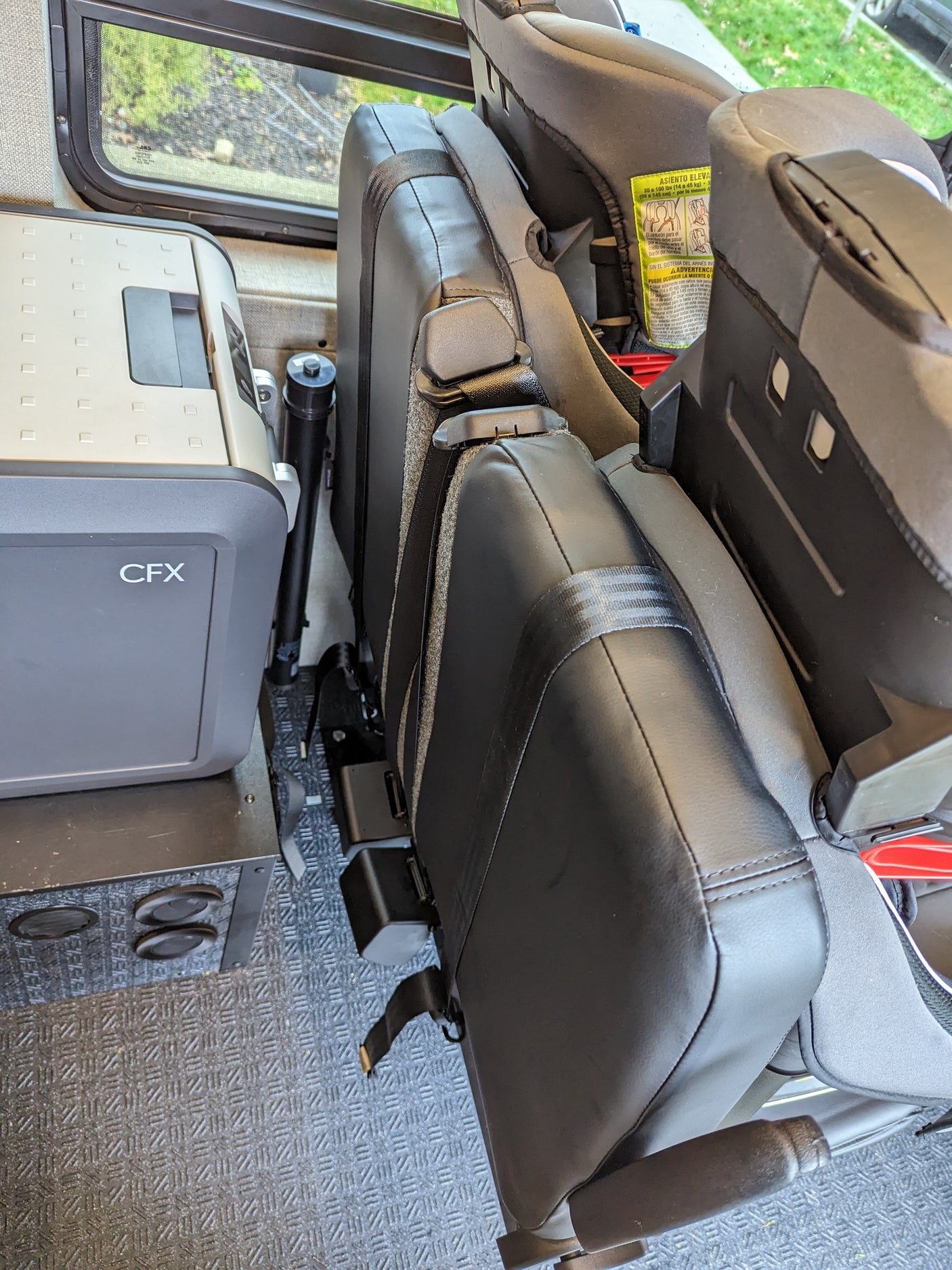 RV rental interior featuring a CFX portable cooler next to a child booster seat, ready for family travel.