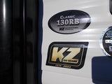 Close-up of a KZ recreational vehicle, highlighting its "CLASSIC 130RB" model and 50-year anniversary (1972-2022) decals, suitable for rv rental.