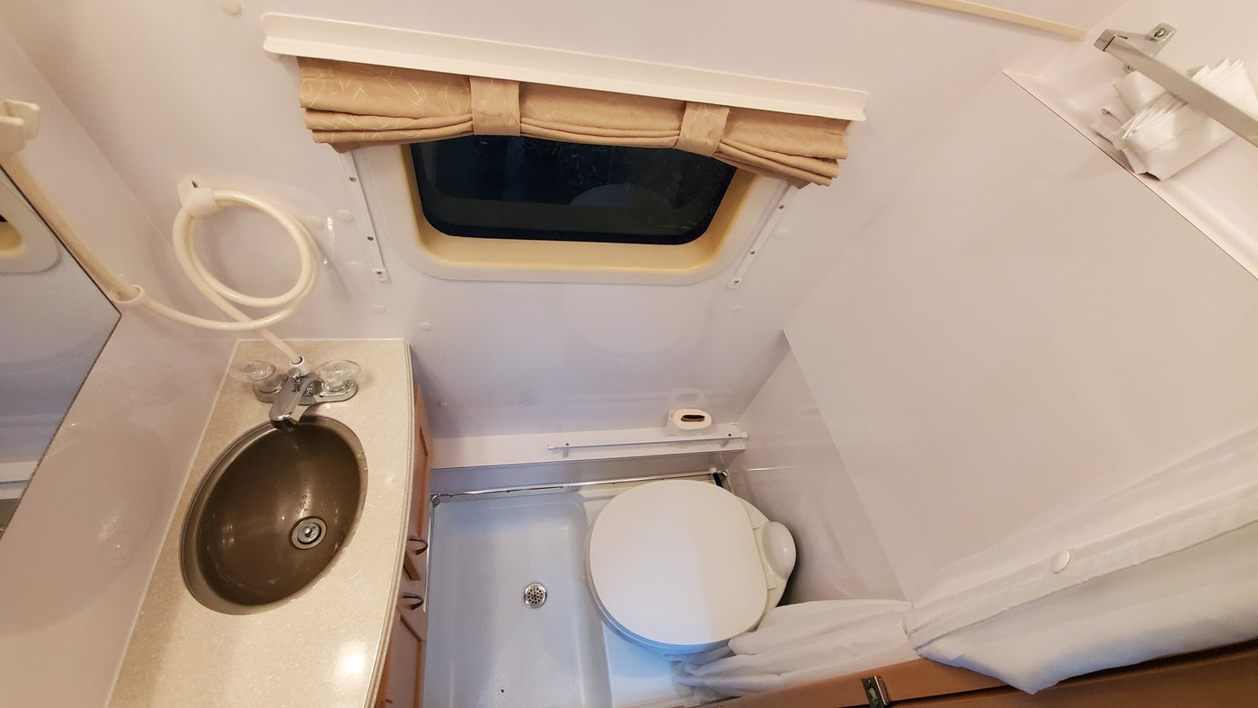  and expandable counter space.|Inside a cozy RV rental: kitchen with stove & sink — photo 15