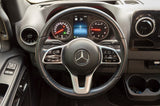 Driver's view of a Mercedes-Benz Sprinter dashboard, ideal for an RV rental. Steering wheel, digital gauges, and controls are visible.