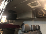 Spacious RV rental interior with a comfortable bed, kitchen area, overhead storage cabinets, and ceiling fan.