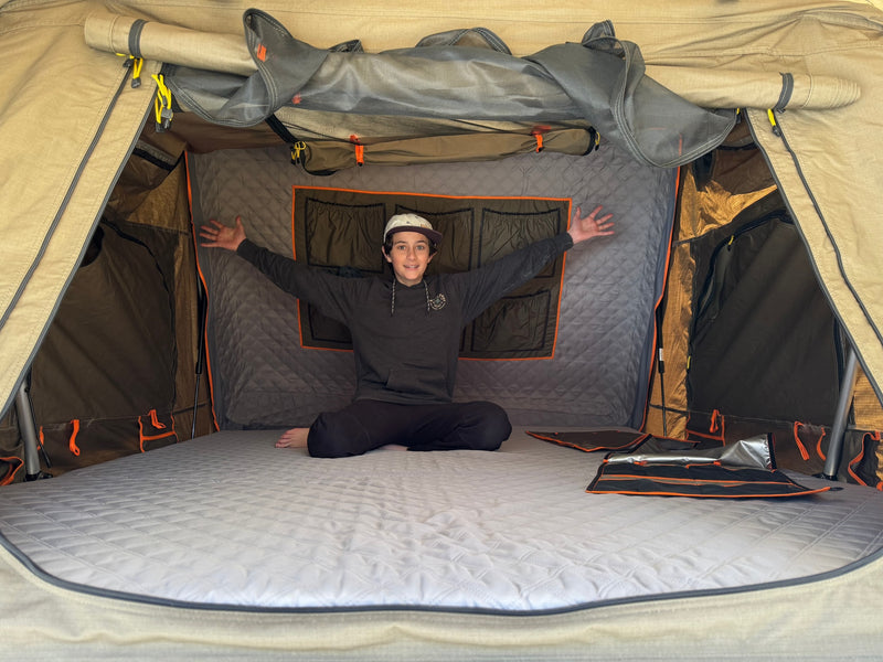 Happy youth in RV rental rooftop tent. See its comfy mattress, storage pockets & mesh windows, great for travel & camping! — photo 16