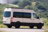 This rugged beige Mercedes-Benz Sprinter camper van, perfect for rv rental, is ready for your next outdoor adventure.