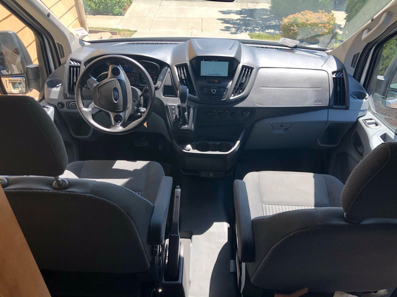  parked door open by the water.|Open RV rental camper van showing interior bed — photo 7