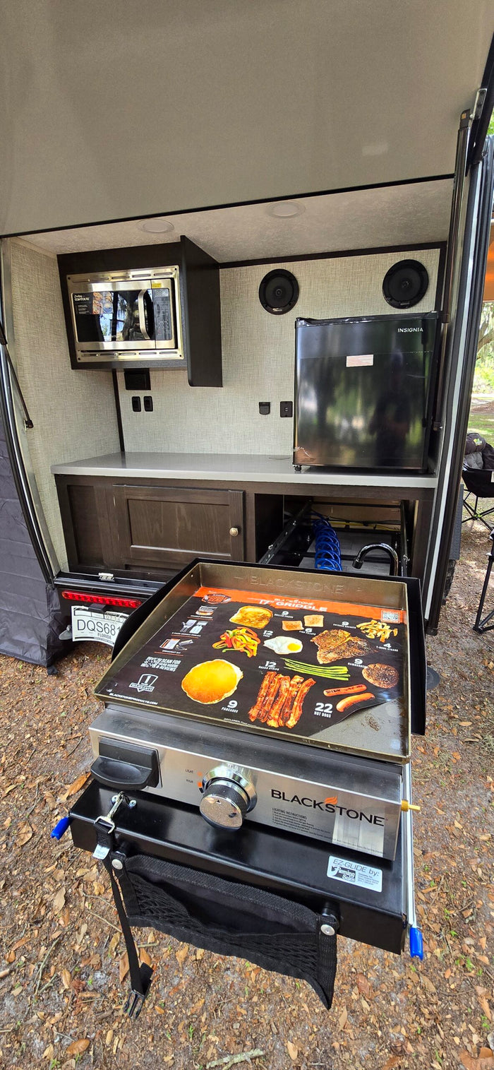 This RV rental features a convenient outdoor kitchen with a microwave, mini-fridge, and pull-out Blackstone griddle for camp cooking.