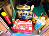 Compact RV rental storage: first aid kit, fire extinguisher, cleaning supplies, and RV-specific toilet paper for travel.