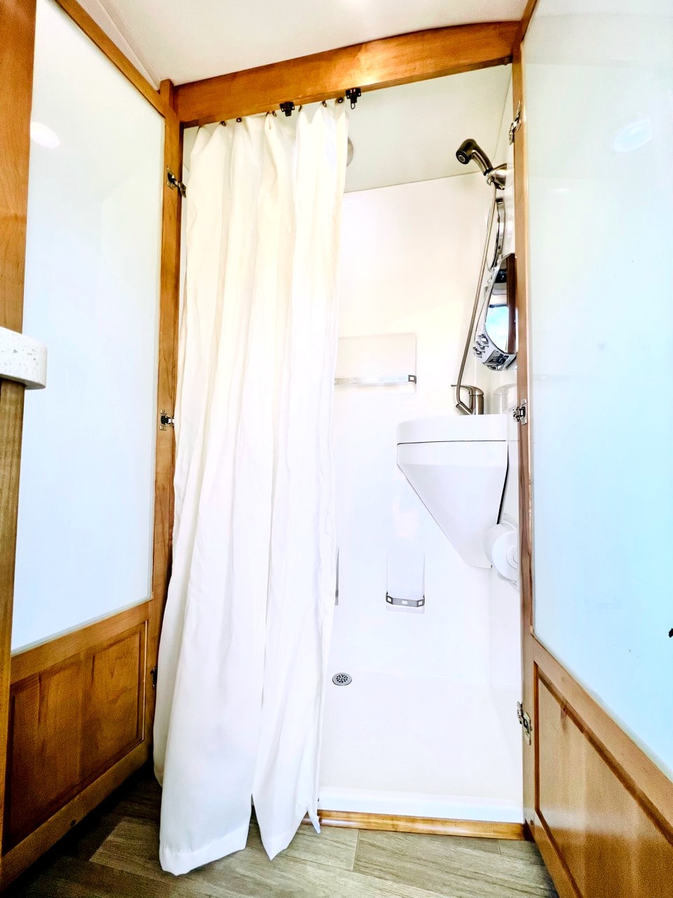 Modern RV rental bathroom: compact shower with curtain, wall-mounted washbasin, and practical amenities for travelers. — photo 19