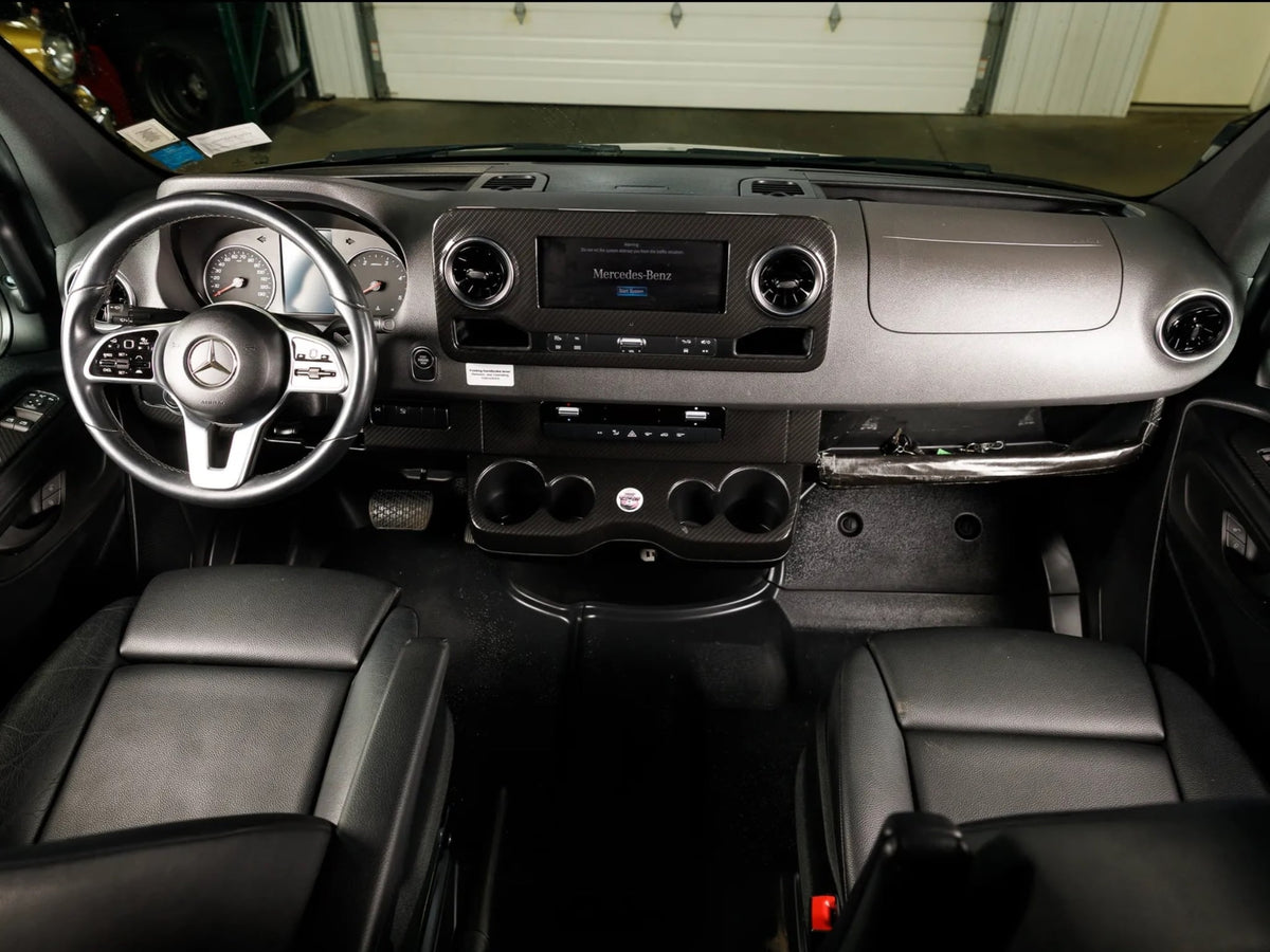  ideal for an RV rental adventure.|Interior of an RV rental showing comfortable black leather front driver and passenger seats with a steering wheel.|If you're seeking a Mercedes-Benz RV rental — photo 6