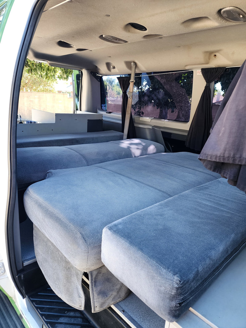 RV rental interior: a flexible camper van with modular blue beds, a compact sink, and overhead lighting for mobile living. — photo 6