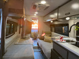 This cozy rv rental interior features a compact kitchen, comfortable beds, and a scenic sunset view, ideal for travel.