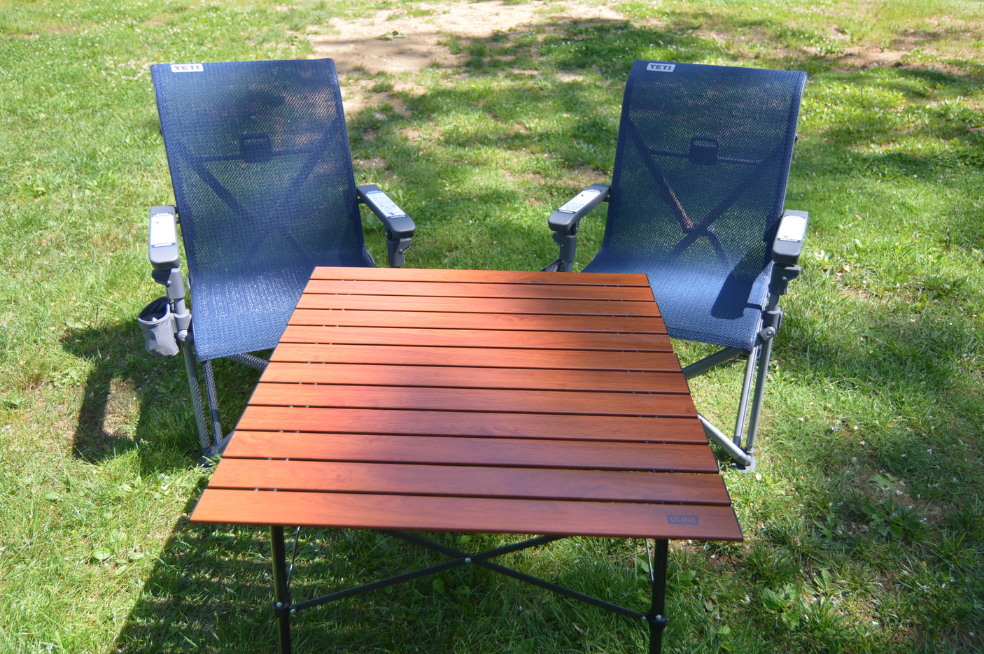 RV rental: YETI camping chairs & portable table on grass, ready for your outdoor adventure.