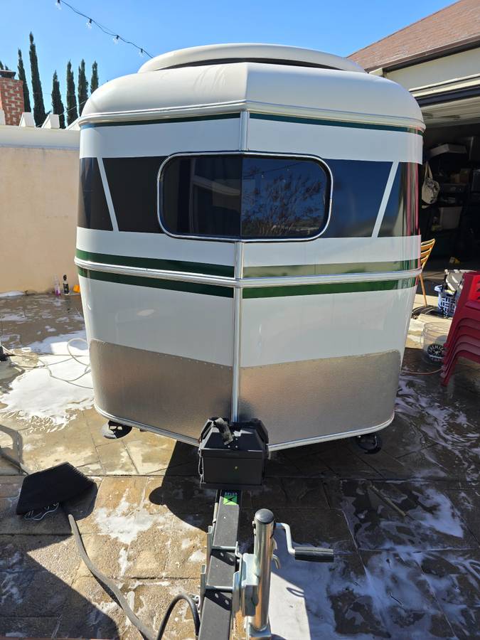  revealing neat wood interior. Perfect for your next trip!|Compact RV rental: A modern white and green teardrop travel trailer — photo 3