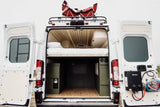 This RV rental campervan shows a comfy bed, under-bed storage, and an outdoor shower. Perfect for van life adventures & mobile living.