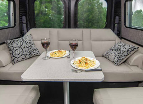 Enjoy a comfortable pasta and wine dinner in your RV rental. This cozy dinette is ideal for relaxing meals on the road.