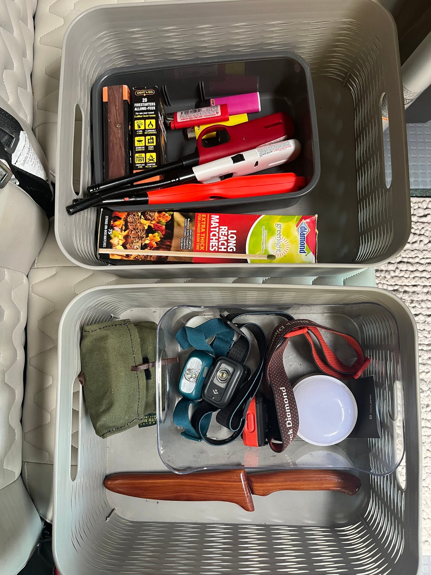 Firestarters, lighters, matches, headlamps, and a camping knife neatly organized in baskets, perfect for an rv rental adventure. — photo 15