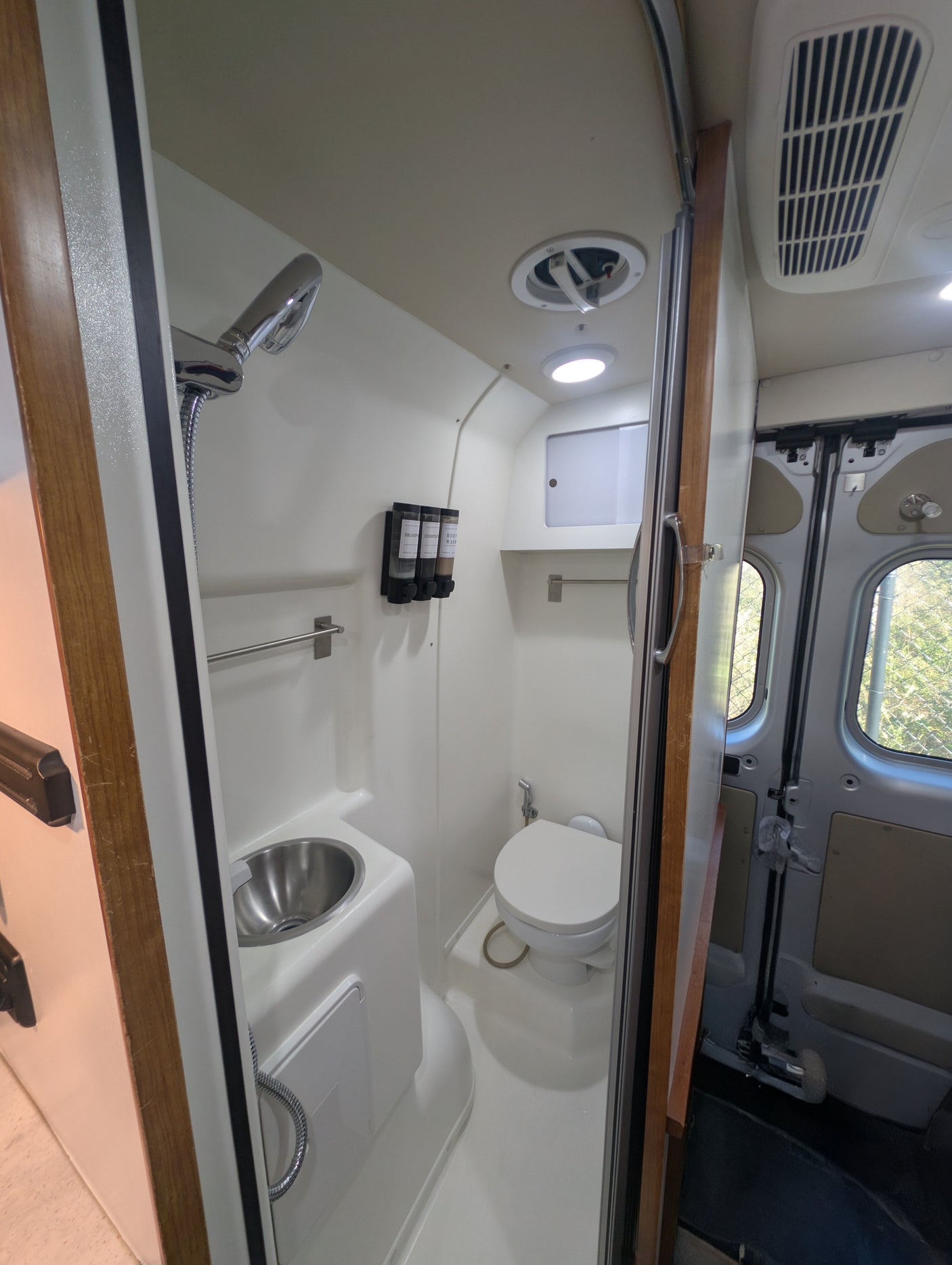 This RV rental features a compact wet bath with shower, toilet, and sink, designed for comfort in your camper.
