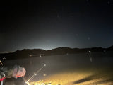 Enjoy tranquil night fishing & stargazing by a lake. An RV rental makes these outdoor adventures under the Pleiades and mountains perfect.