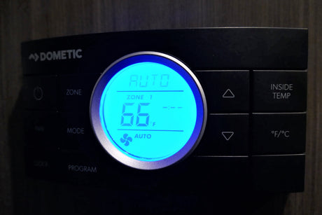 Digital Dometic thermostat in an rv rental set to 66°F, showing auto mode. Essential for RV climate control.