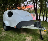 Discover this MyPod teardrop **rv rental**, perfect for scenic camping trips. Parked by a lake reflecting a vibrant sunset.