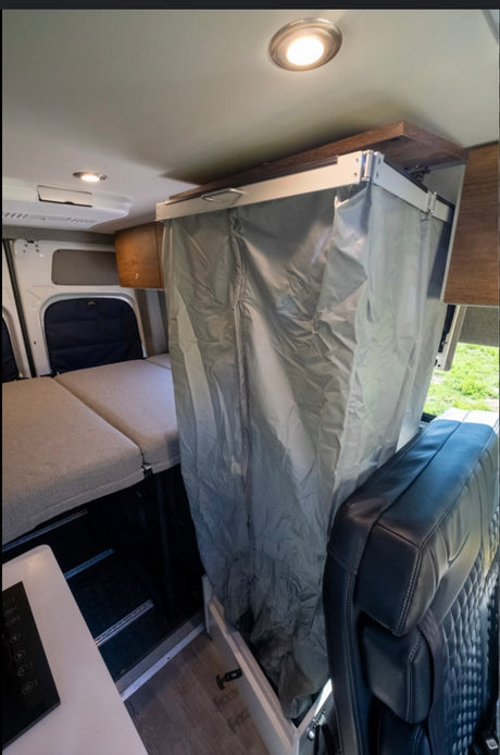Our RV rental offers a well-designed camper van interior with a bed, integrated shower, and compact kitchen.