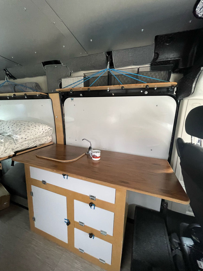  and 'Happy Camper' mug visible.|RV rental: Inside this black camper van — photo 14