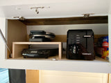 RV rental kitchen cabinet with Cuisinart toaster, waffle maker, and NuWave induction cooktop. Custom shelving & secure latches.