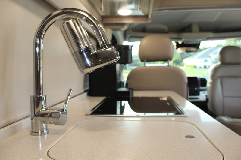  and compact bathroom.|Modern RV rental bedroom featuring a large — photo 8