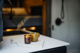 Cozy RV rental interior with a lit candle and a warm drink on a counter, perfect for relaxing moments.