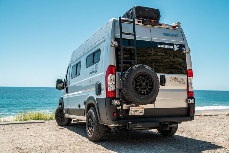 This Winnebago Solis Pocket camper van, ideal for an rv rental, is parked on a scenic beachside overlooking the blue ocean. — photo 5