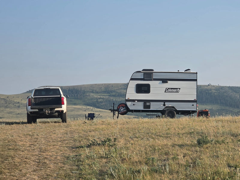 RV rental camping with a white truck & Coleman travel trailer in a vast — photo 1