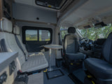 Interior of an rv rental, showcasing versatile seating, removable table, and the driver's cockpit.