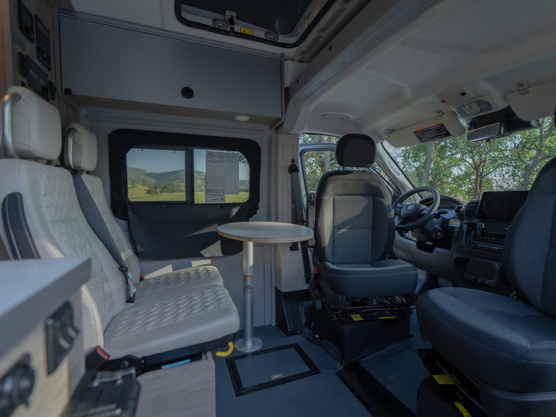 Interior of an rv rental, showcasing versatile seating, removable table, and the driver's cockpit. — photo 9