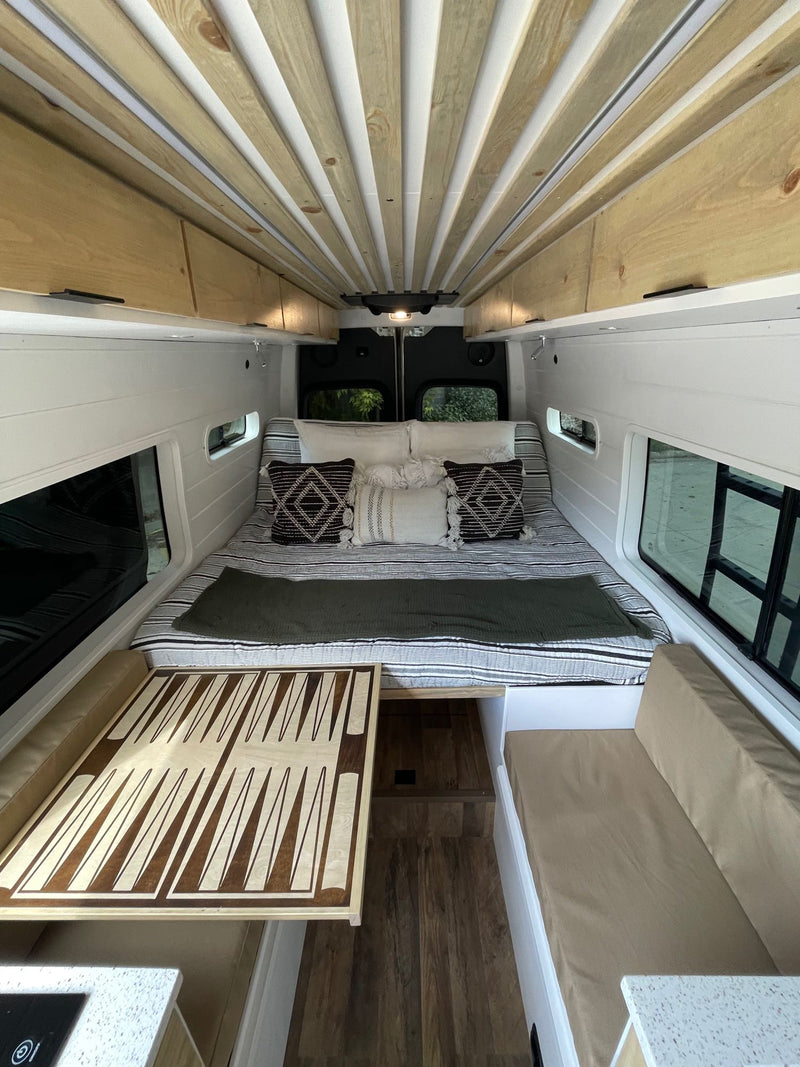  and wood interior. Ideal for adventure.|RV rental: Modern camper van interior with adaptable dining. Features chessboard and backgammon tables — photo 6