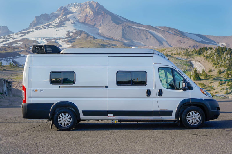 This light-gray Solis camper van for rv rental is parked on asphalt — photo 1