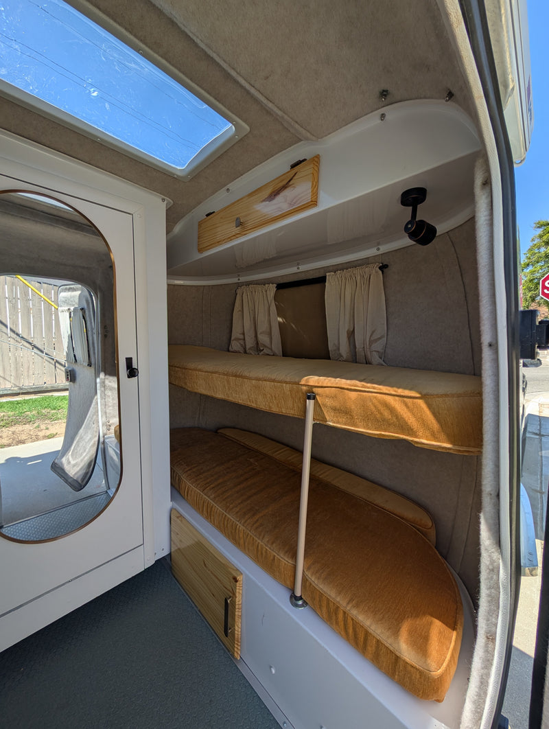 RV rental camper interior featuring cozy bunk beds, a skylight, and compact design, perfect for travelers. — photo 3